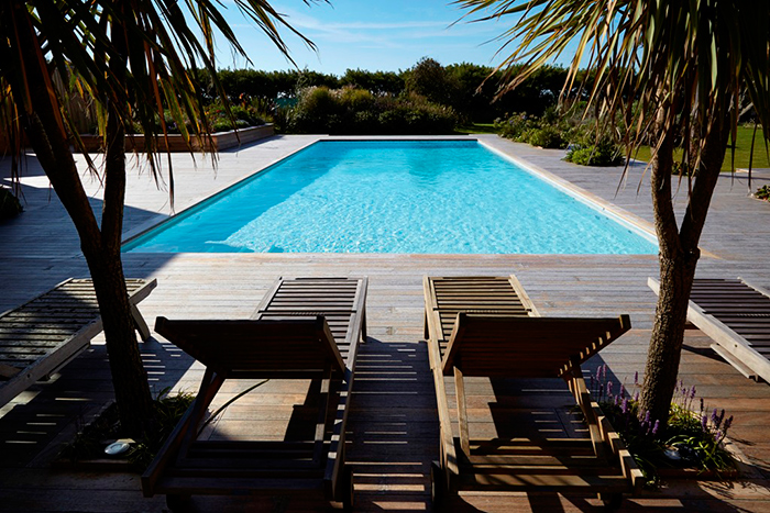 Natural materials meet contemporary design in a luxury outdoor swimming pool on the South Coast