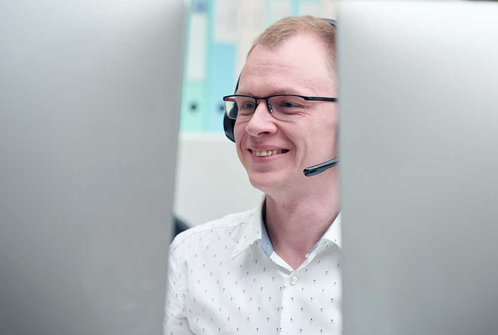 Customer service team member with a headset on sitting on desk