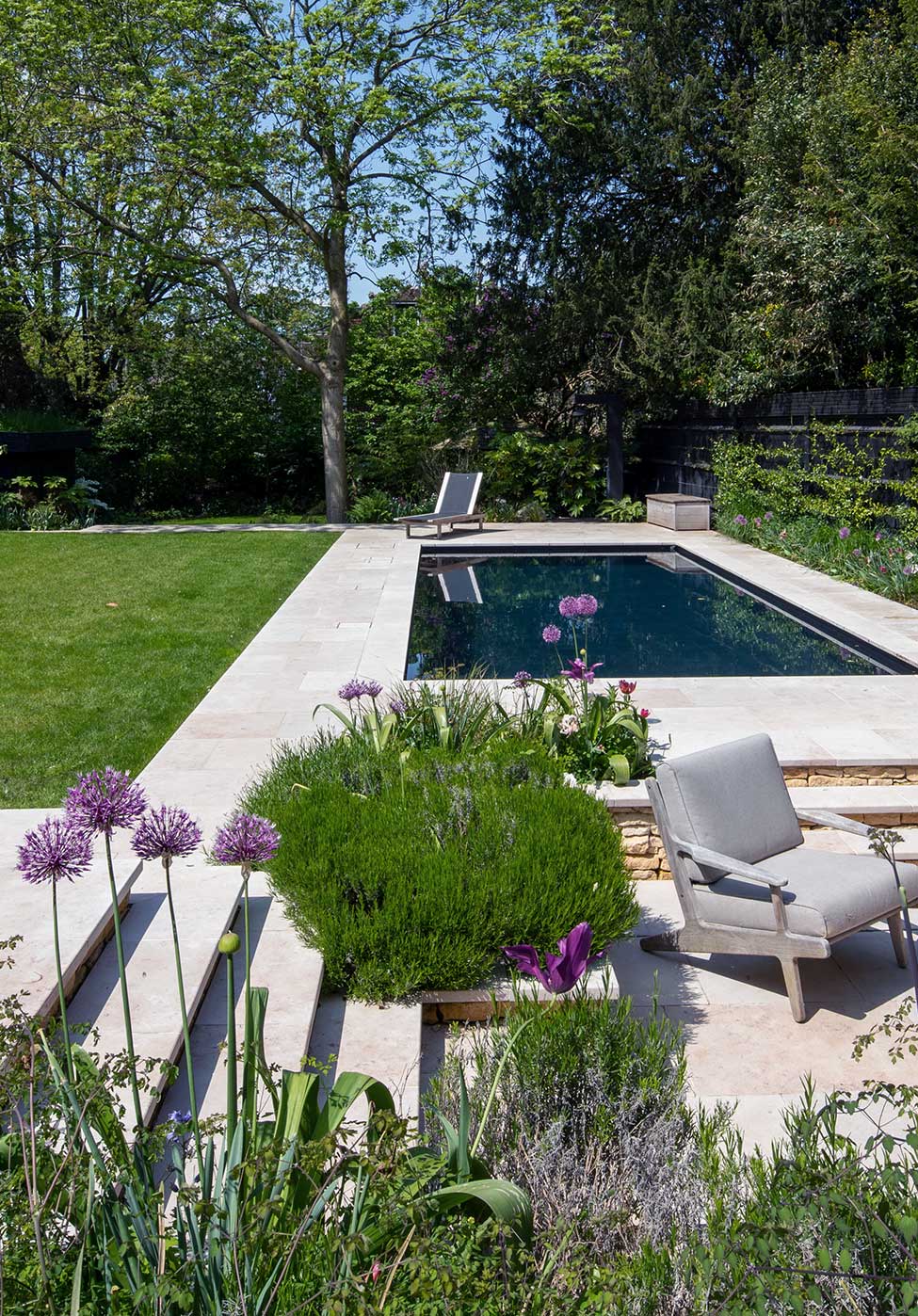Outdoor pool in a well kept garden with flowers